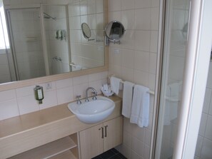 Habitación superior, 1 cama Queen size, cocineta | Baño | Regadera, regadera tipo lluvia, amenidades de baño gratuitas