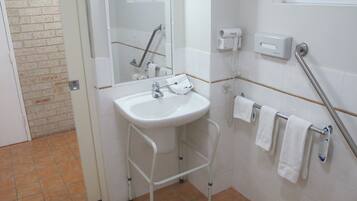A bathroom with a white sink, a mirror, a towel rack, and a hand dryer.