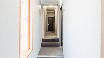 Ein moderner Hotelkorridor mit einer Treppe, die zu einer Tür mit der Nummer 21 führt.