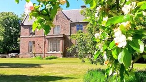 A large stone building with multiple windows and a well-maintained lawn. - The Gables (Berwick-upon-Tweed)