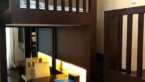 Une pièce comprenant un bureau en bois, une chaise, une petite table et un lit.
