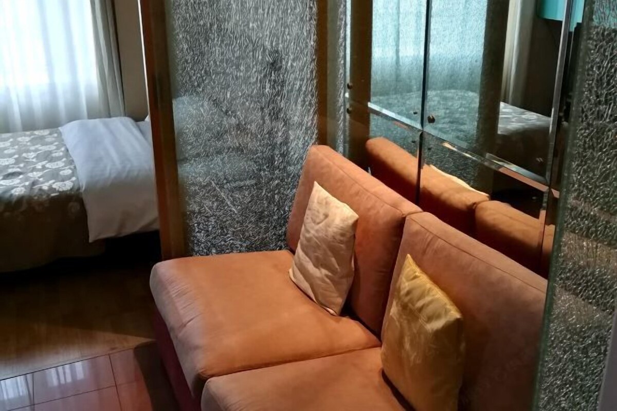 A room with a sofa and a bed.