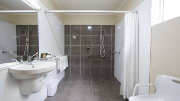 Ein modernes Badezimmer mit Waschbecken, Spiegel, Dusche und Toilette.