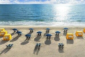 En la playa, camastros, sombrillas y toallas de playa 