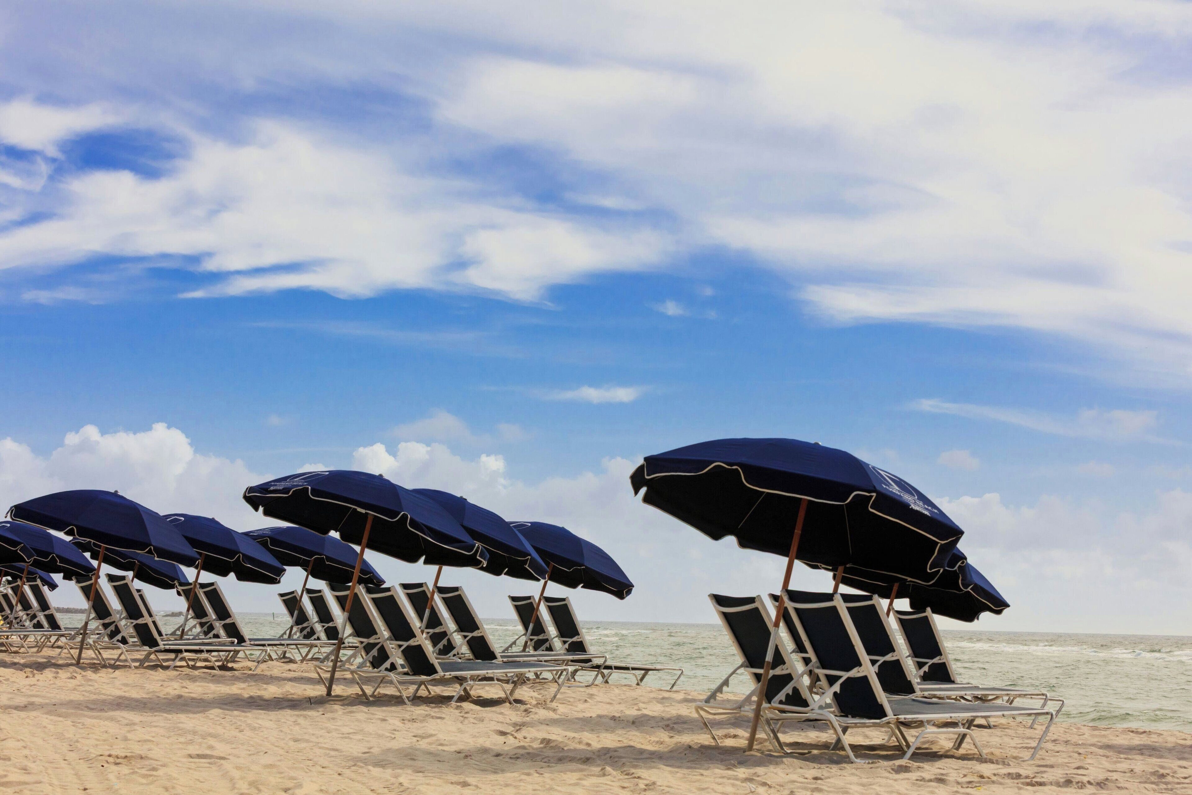 På stranden, solsenger, parasoller og strandhåndklær
