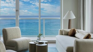 A room with a large window, a sofa, a chair, a small table, and a lamp. - Fort Lauderdale Marriott Pompano Beach Resort (Pompano Beach)