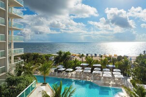 En la playa, sillas reclinables de playa, sombrillas, toallas de playa