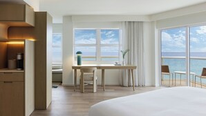 A modern hotel room with a large bed, a desk, and a view of the sea. - Fort Lauderdale Marriott Pompano Beach Resort (Pompano Beach)