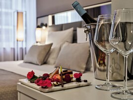 A dining setup with a bottle of wine, two glasses, and a dessert on a tray.