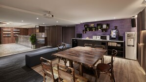 Une cuisine moderne avec un coin repas, des appareils électroménagers intégrés et un projecteur fixé au plafond.