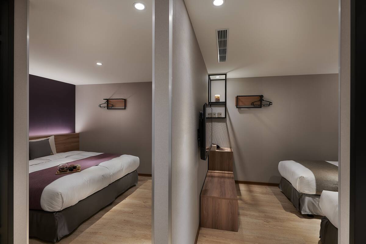 Ein modernes Schlafzimmer mit einem Bett, Nachttischen und einem integrierten Fernseher.