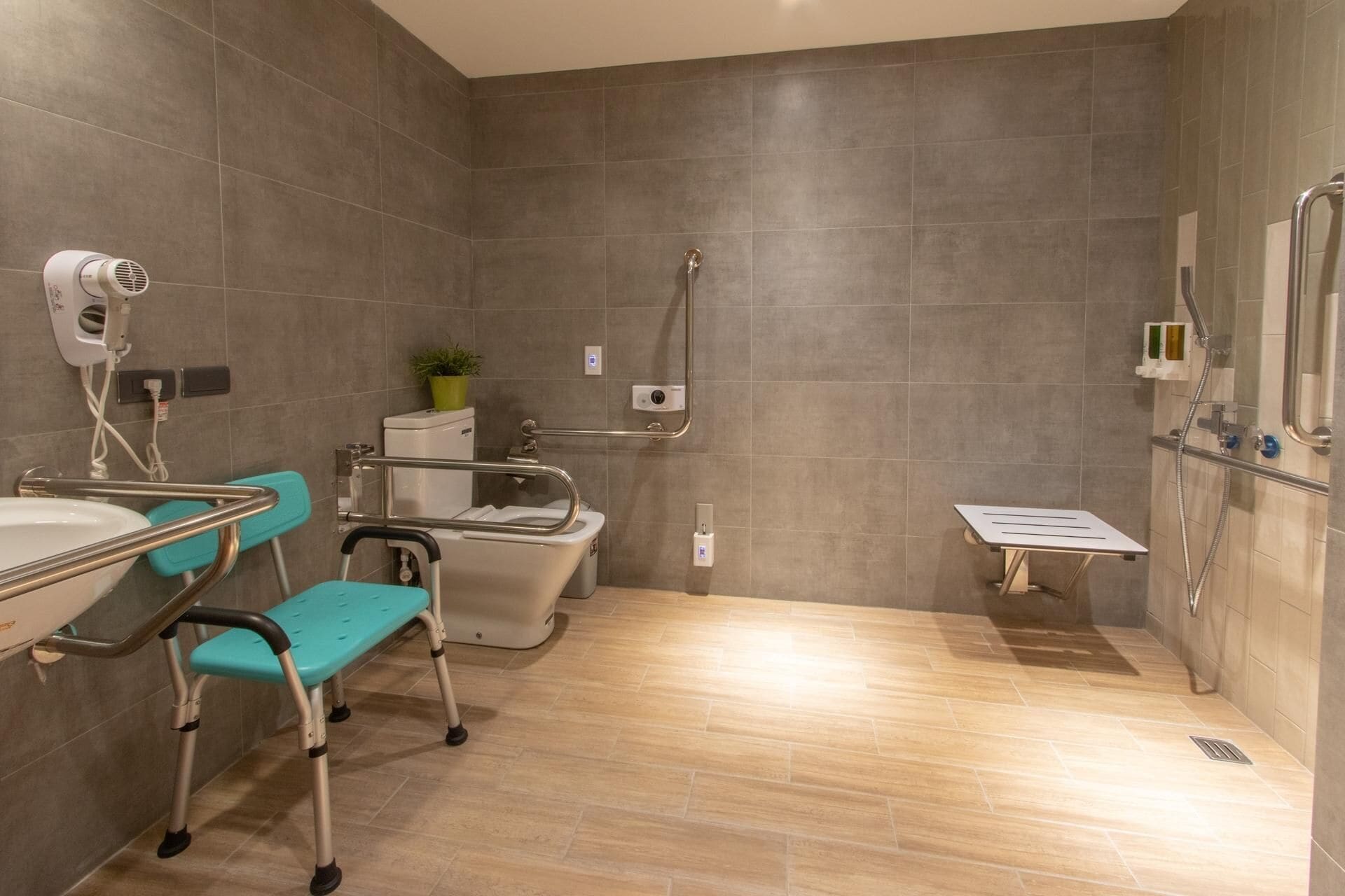 A modern bathroom with a shower, toilet, and sink.
