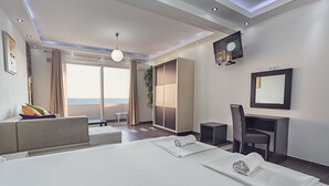 A modern hotel room with a large bed, a desk, a chair, a TV, and a view of the ocean. - David Dobre Vode (Bar)