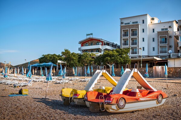 A beach with colorful water slides and lounge chairs.