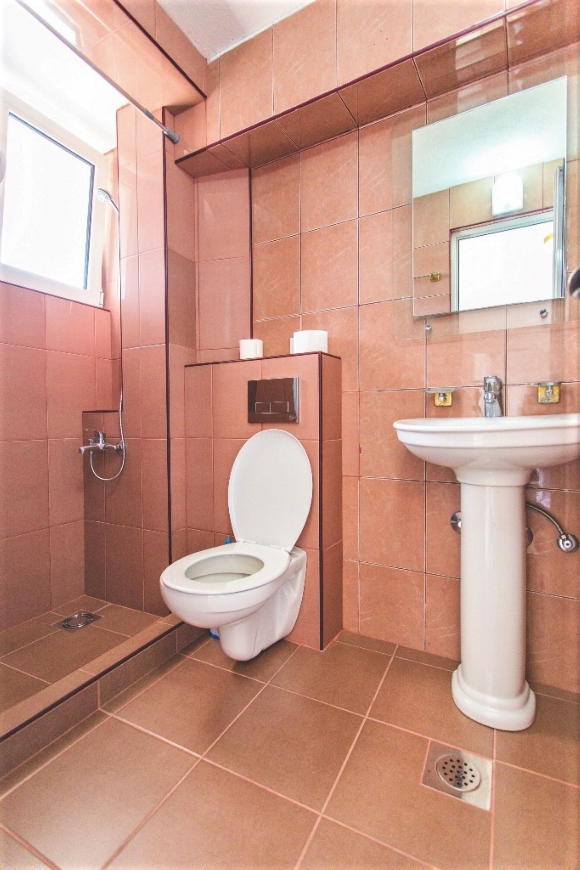 Een badkamer met toilet, wastafel en douche.