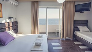 A hotel room with a bed, a TV, a balcony with a view of the sea, and an air conditioning unit. - David Dobre Vode (Bar)