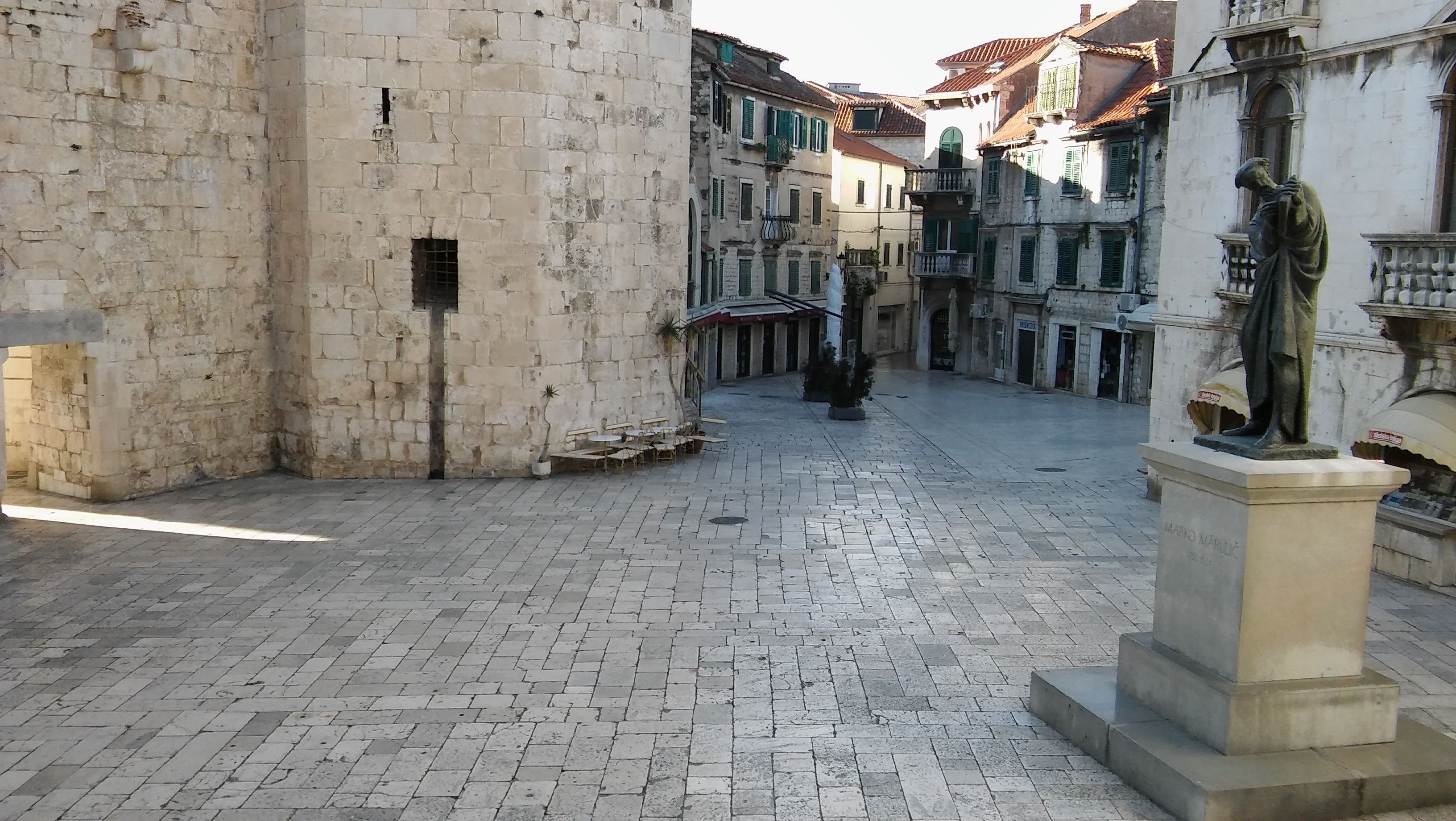 A courtyard with stone walls and a statue.