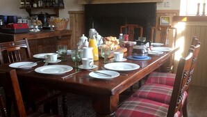 A dining table set with plates, cutlery, glasses, and a variety of food items. - Balsporran Bed And Breakfast (Dalwhinnie)