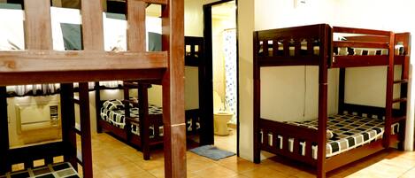 A room with bunk beds, a wooden chair, and a tiled floor.