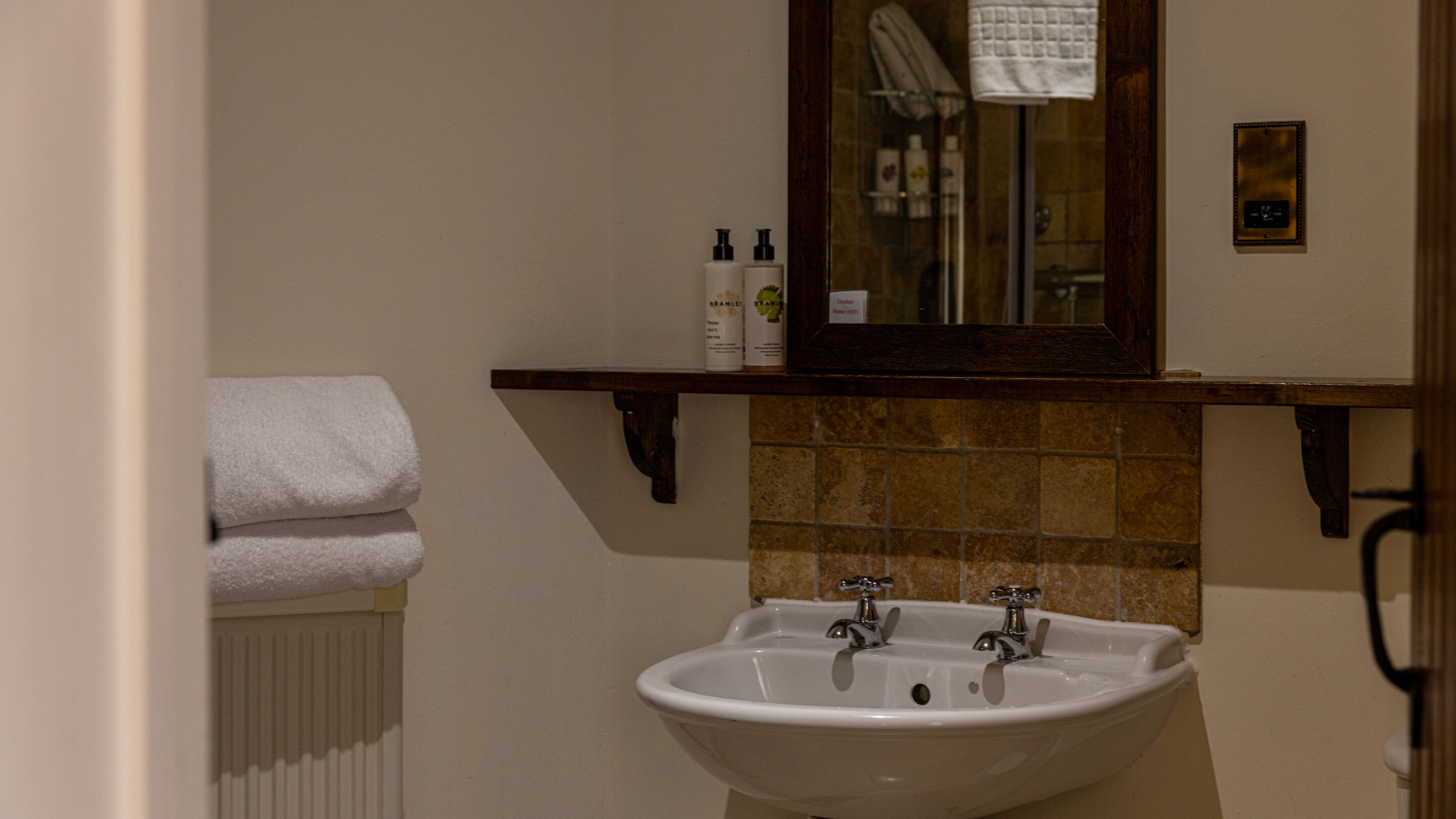A bathroom with a white sink, a mirror, and a towel rack.