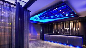 A modern interior with a reception desk, a patterned wall, and a ceiling with blue lighting. - The Tango Taipei ChangAn (Taipei)