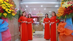 A hotel reception area with a marble reception desk, a chandelier, and a red carpet leading to the entrance.