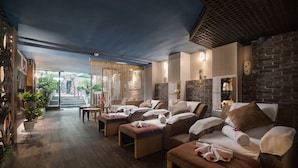 Un área de spa con sillones de masaje, una recepción y vistas a la calle.