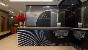 Een receptiebalie met een modern design, met een logo en een digitaal scherm.