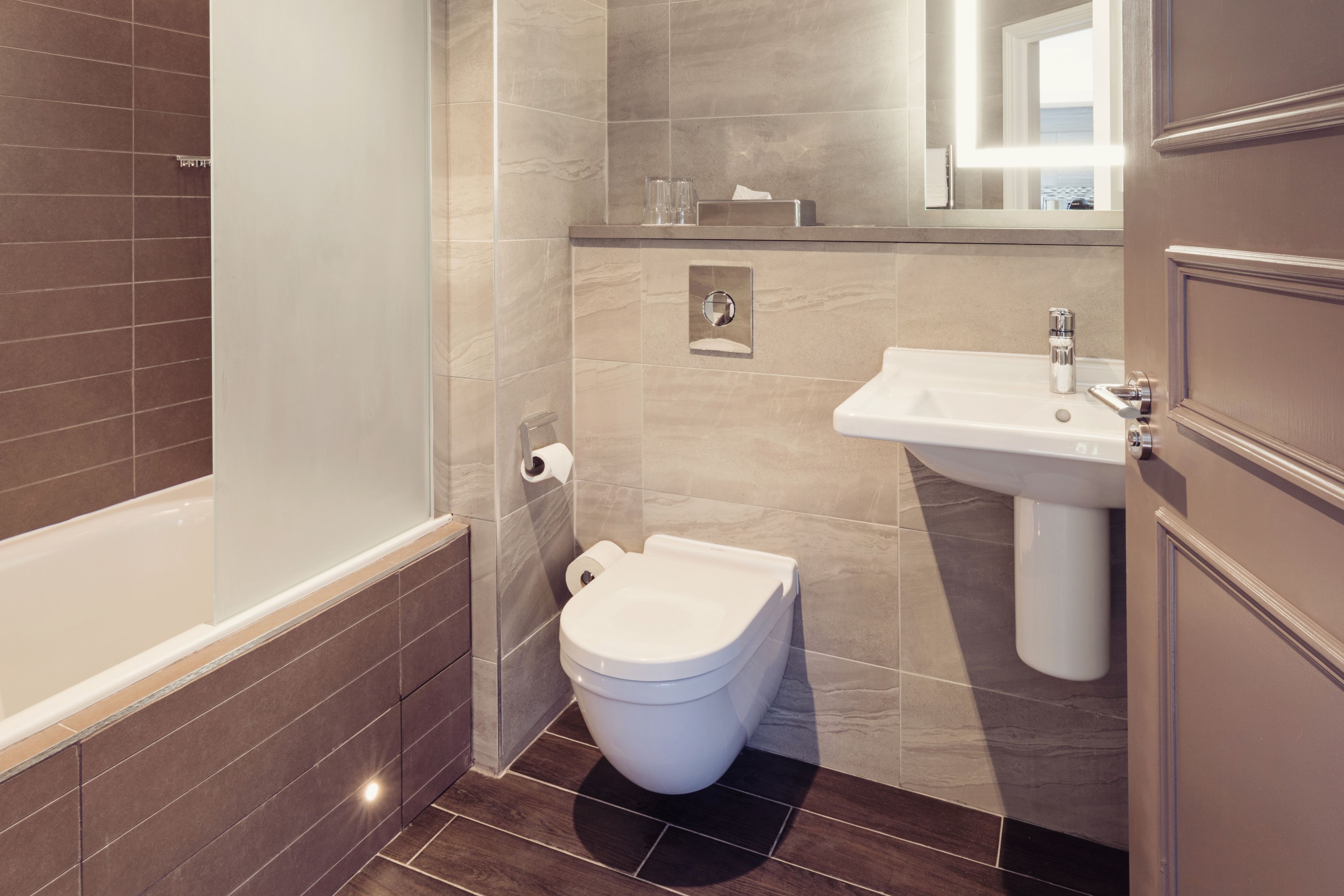 A modern bathroom with a bathtub, toilet, and sink.