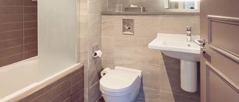 A modern bathroom with a bathtub, toilet, and sink.