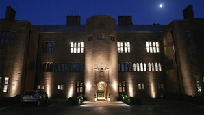 A large, historic building with a central entrance, multiple windows, and a moon in the sky. - Abbey House Hotel (Barrow-in-Furness)