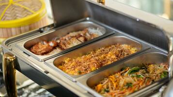 Un buffet proposant une variété de plats, notamment des plats frits, du riz et des légumes.