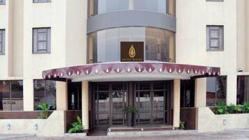 Fachada de hotel moderna, con grandes ventanales de vidrio y un logotipo destacado.