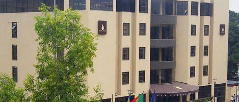 A multi-story building with a flat facade, large windows, and a central entrance with a covered area.