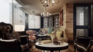 A modern living room with a sofa, armchairs, a coffee table, and a chandelier. - Hotel Royal (Kinshasa)