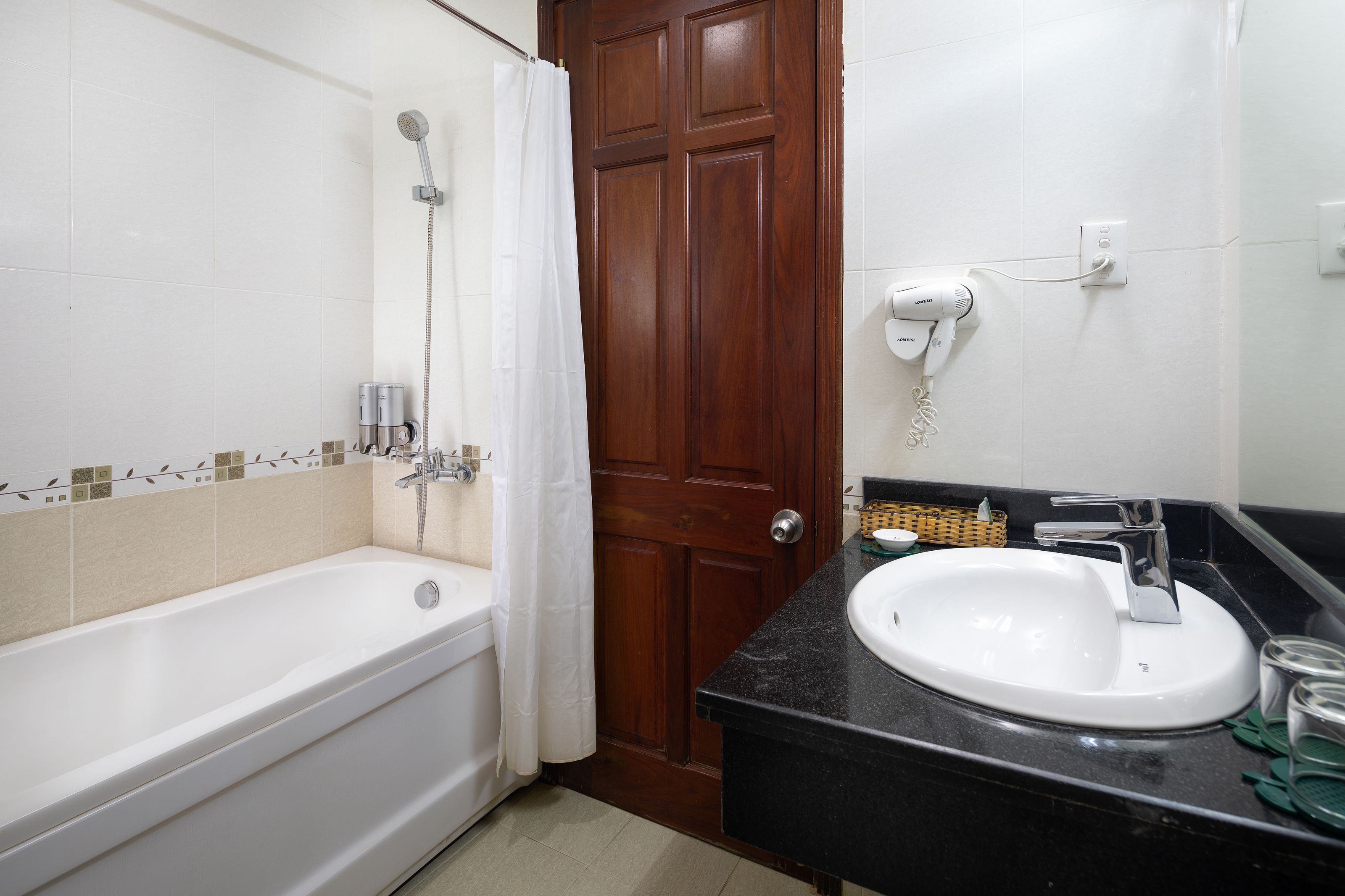 Un baño con bañera, ducha, lavamanos y espejo.