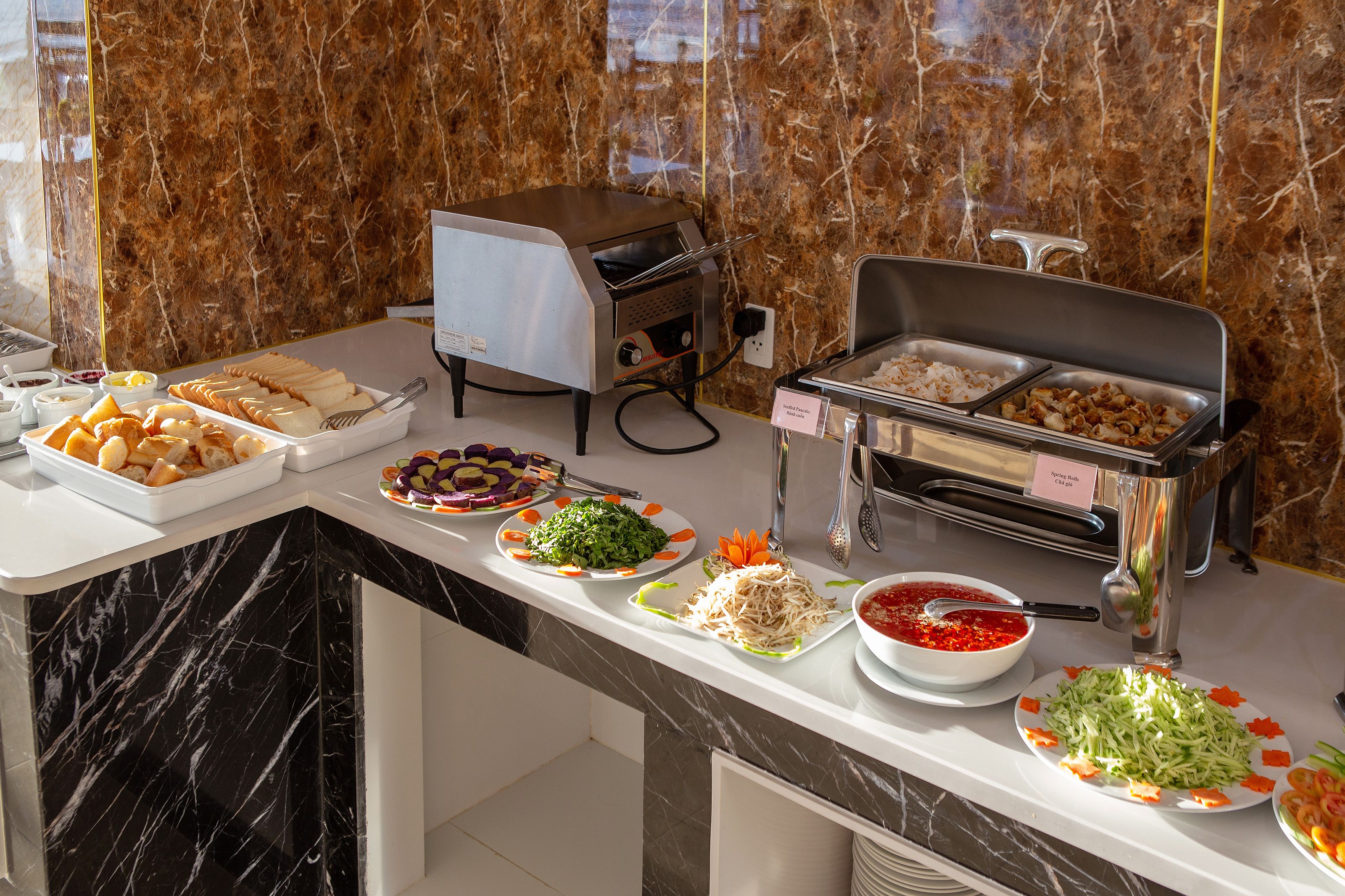 A buffet setup with various food items and a self-service beverage station.