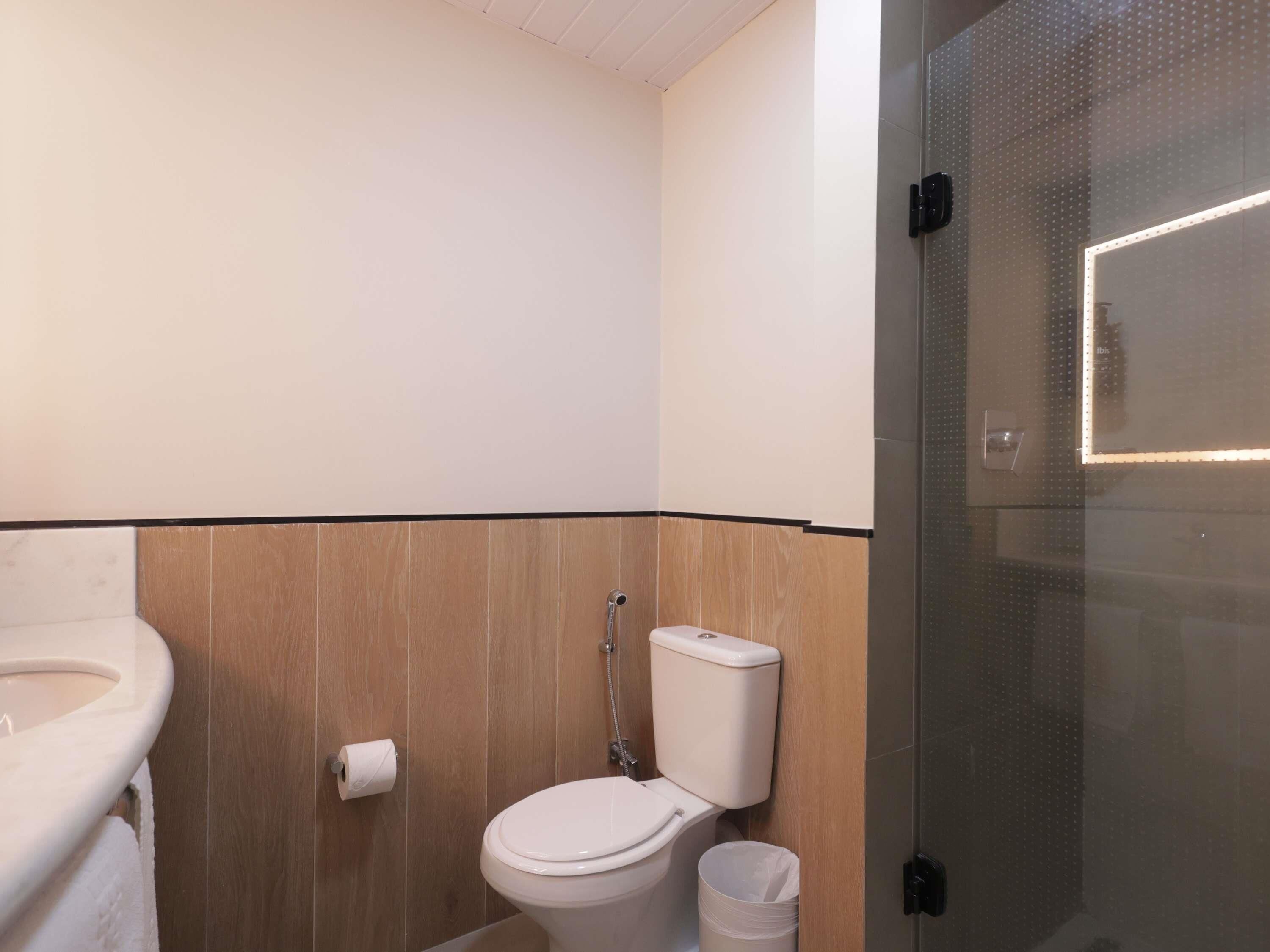 Un baño con inodoro, lavabo y zona de ducha.