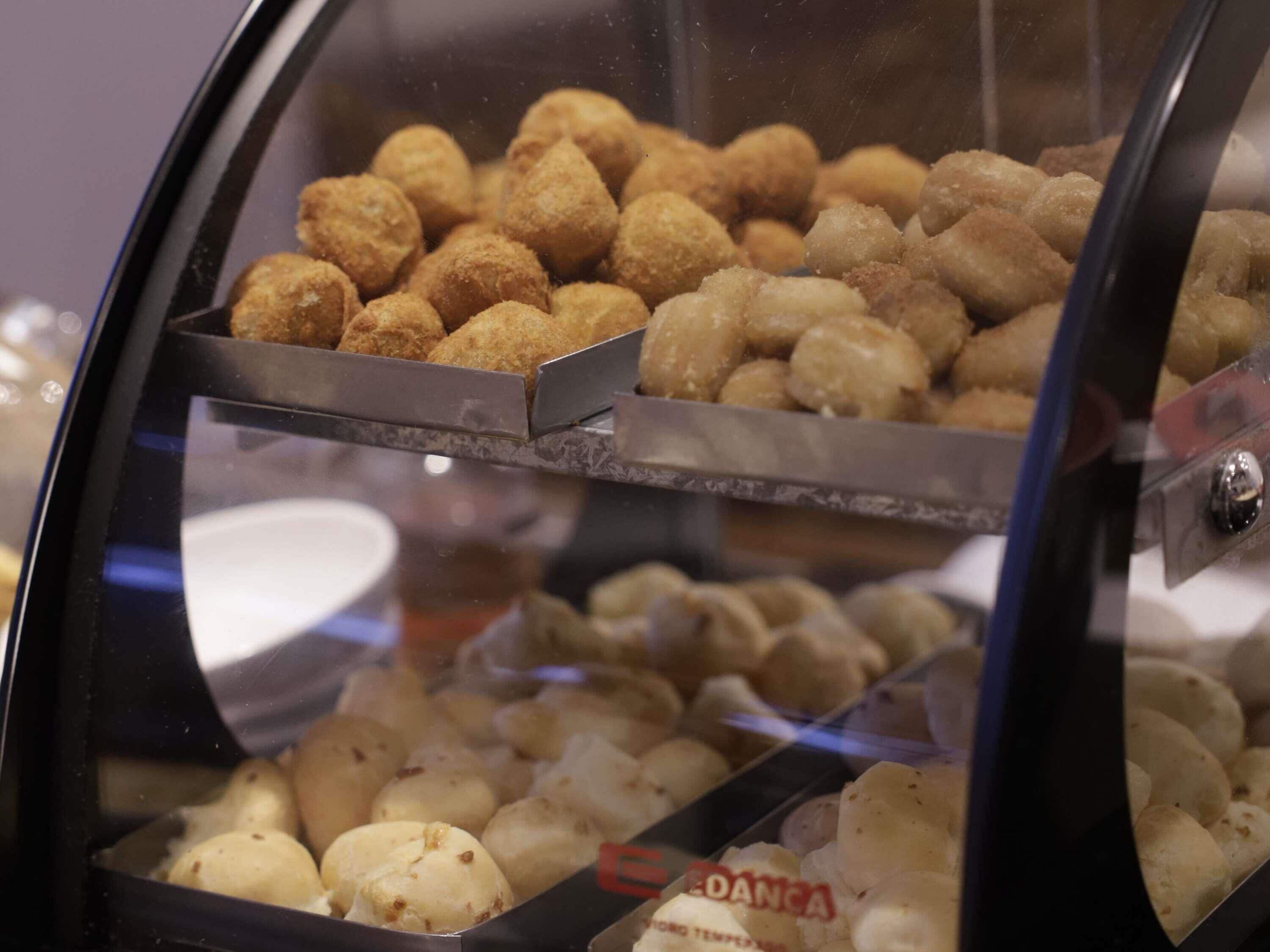 Una vitrina con diversos alimentos, incluyendo opciones empanizadas y fritas.