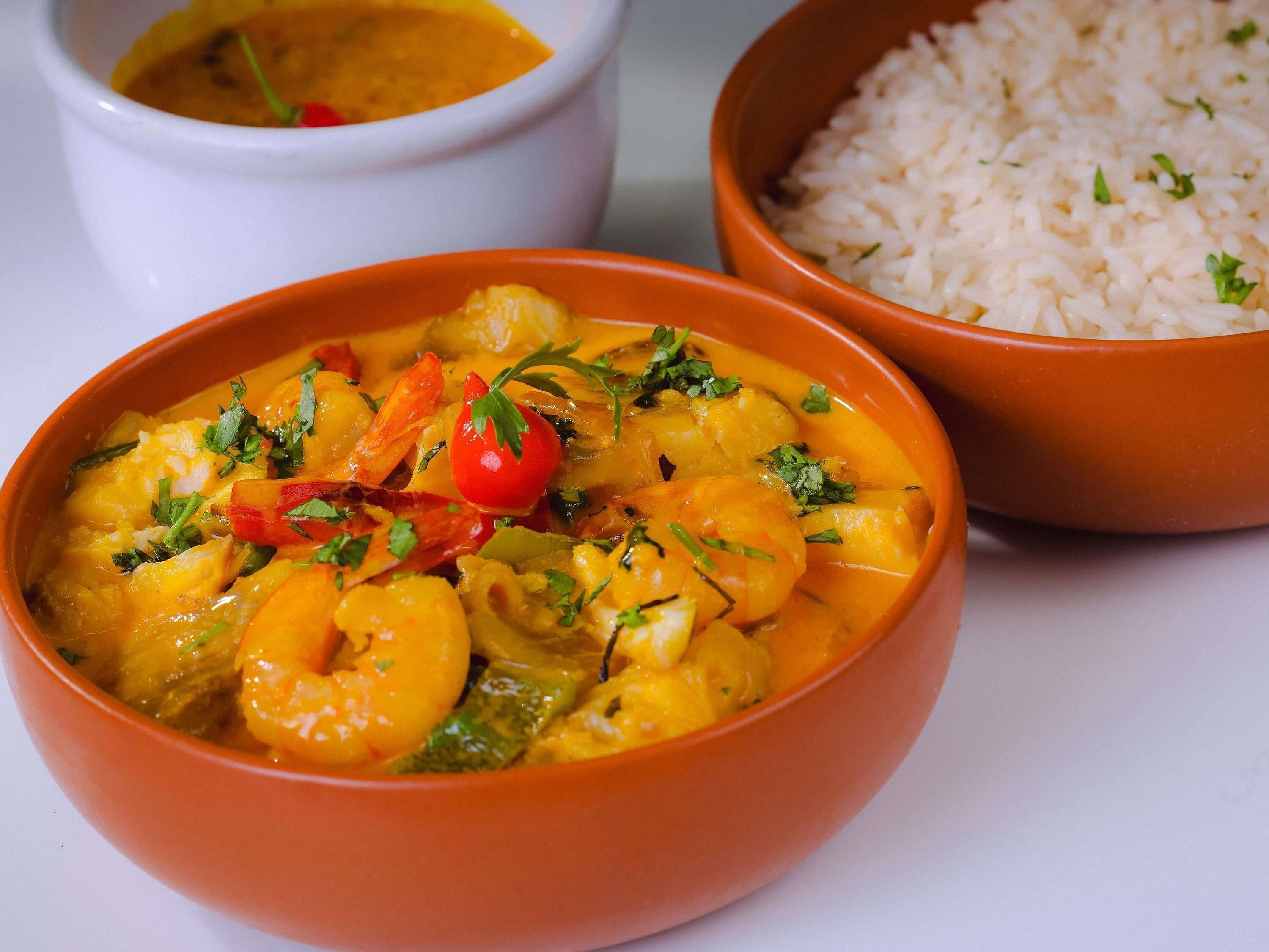 Dos platos de comida, uno con camarones y verduras, y otro con arroz.