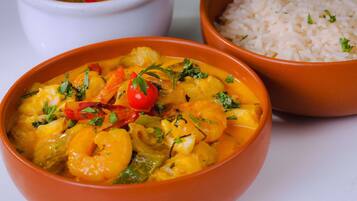 Dos platos de comida, uno con camarones y verduras, y otro con arroz.