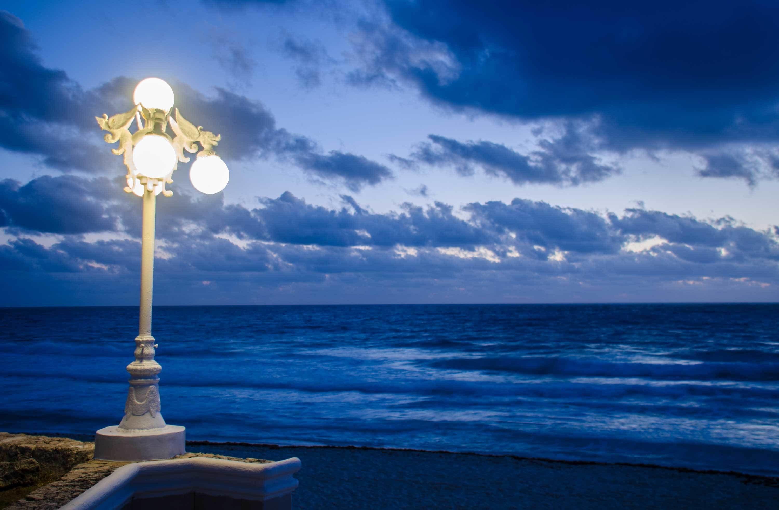 A coastal scene with a street lamp and ocean view.