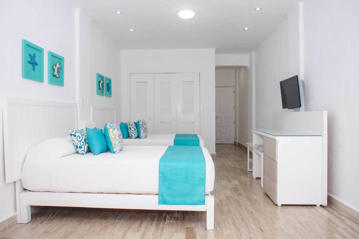 Un dormitorio con cama, escritorio y televisión.