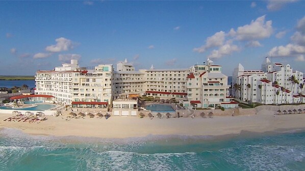 Ein großes Resort mit mehreren Schwimmbecken, Strandvillen und einem Strandabschnitt.