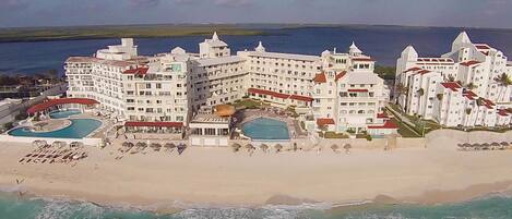 A beachfront hotel with multiple swimming pools, a beach area, and ocean views.