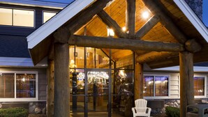 Un chalet avec une façade en bois et une entrée en verre.