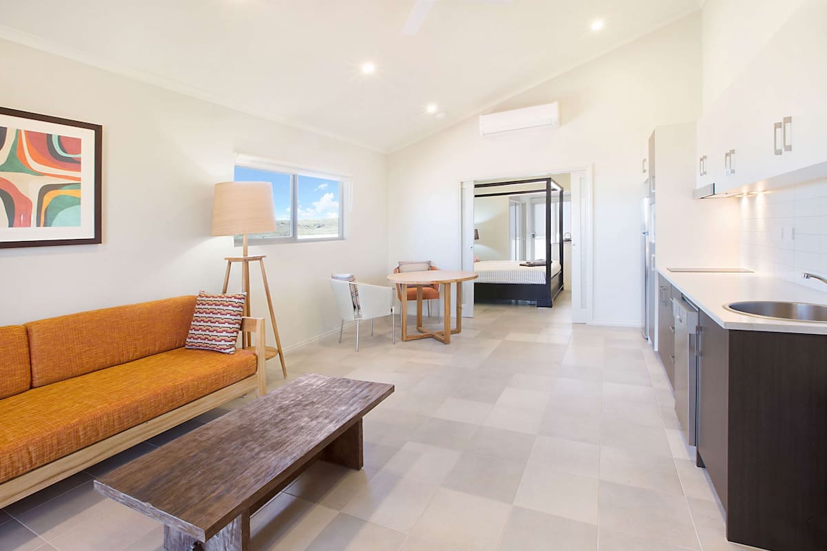 Un appartement moderne comprenant un espace de vie, une table à manger et une cuisine.