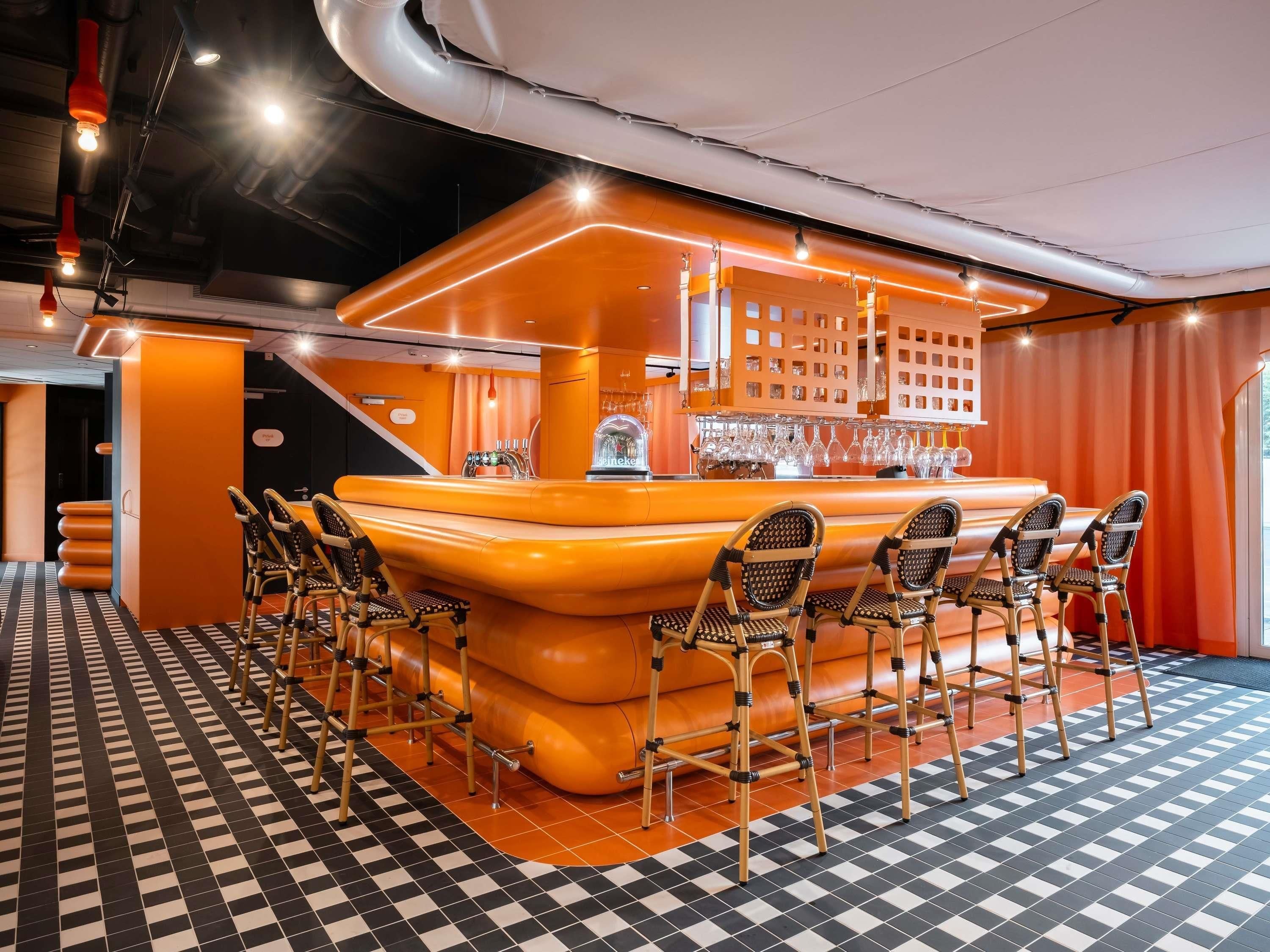 A bar area with a checkered floor, bar stools, and a bar counter with a glass display.