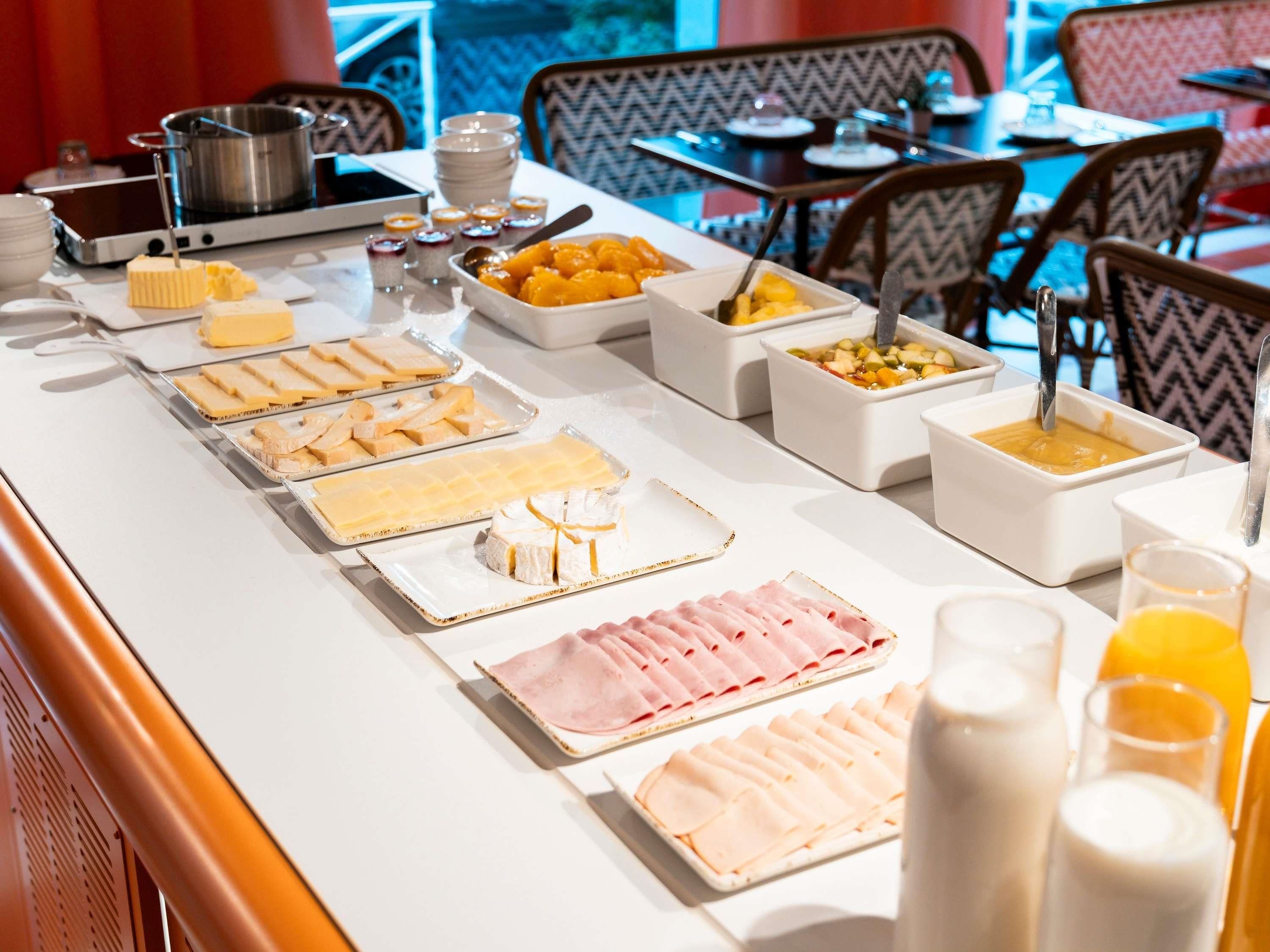 Un buffet proposant une variété de plats et un coin où l’on peut préparer une fondue.