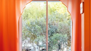 A room with a large arched doorway leading to an outdoor area with trees and a view of the sea. - ibis Styles La Rochelle Centre les Minimes (La Rochelle)